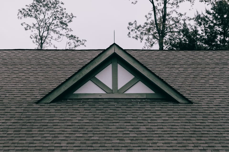 A gabled dormer set into a grey asphalt shingle roof